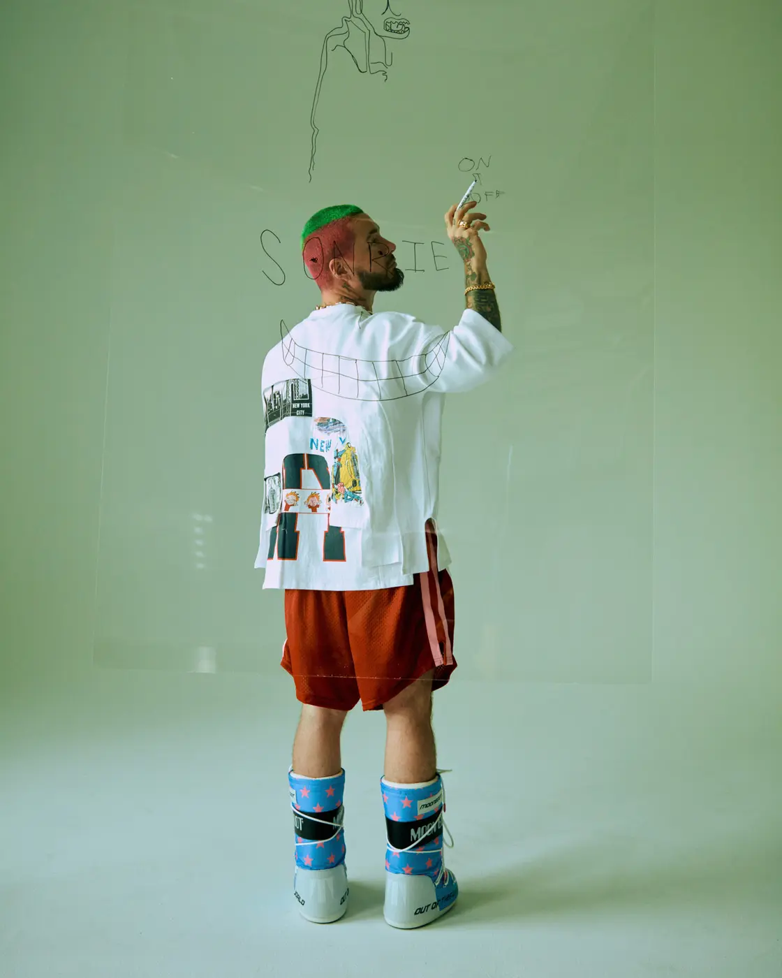 J Balvin standing in a pale green constructed set