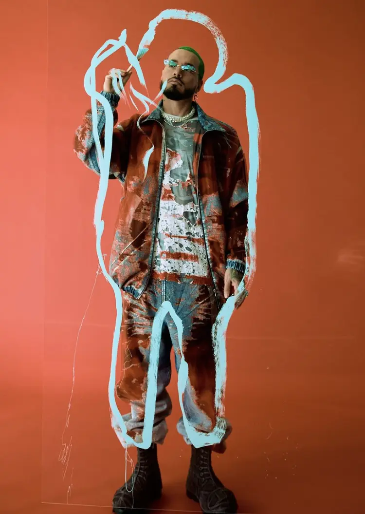 J Balvin against an orange set with a painted white outline