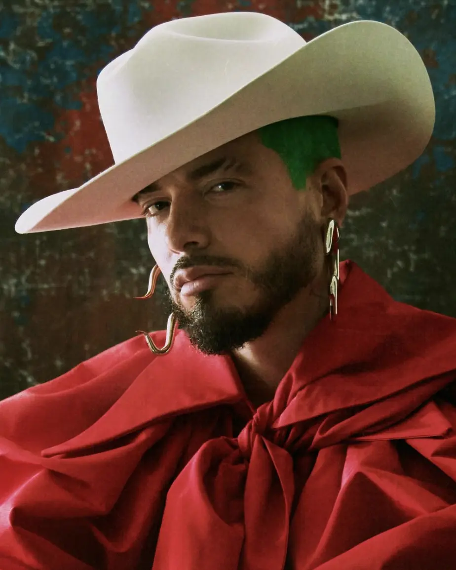 J Balvin in red tailoring and a white hat